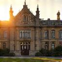 Facade of a stately historic mansion converted into a luxury hotel, with elegant landscaping.